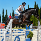 Jeune fille sautant un obstacle bleu lors d'un concours de sauts d'obstacles